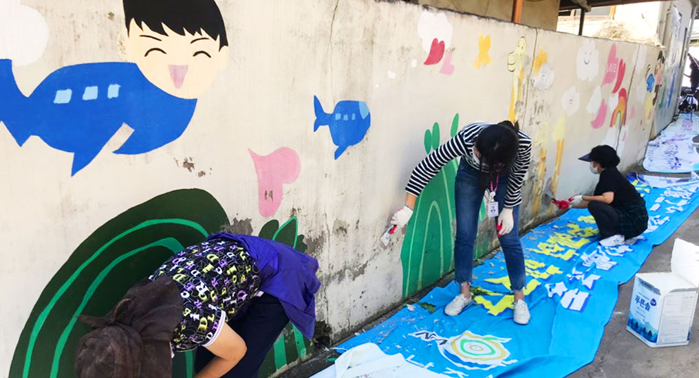 사람들이 낡은 벽면에 그림 그리고 칠하는 모습