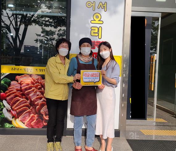 선결제 캠페인 안내판을들고 가게정문앞에서 촬영한 사진