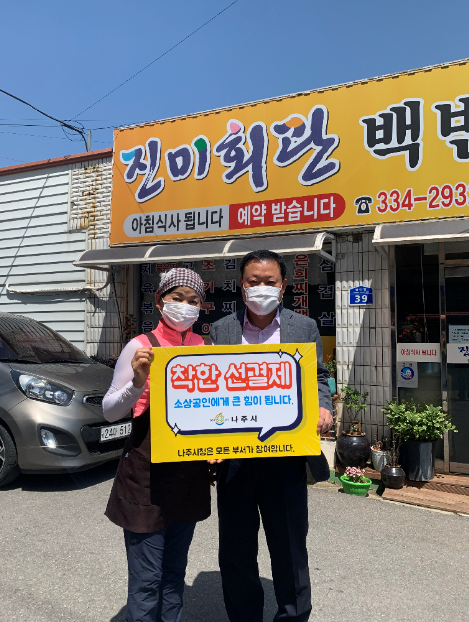 선결제 캠페인 안내판을들고 가게앞에서 촬영한 사진